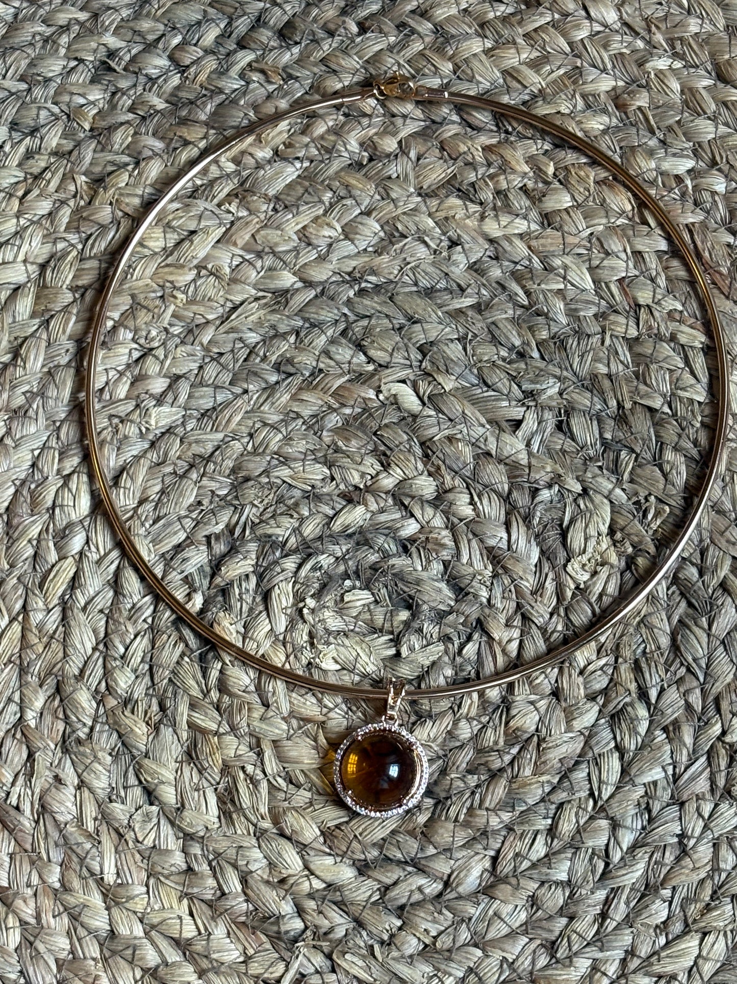 Gargantilla rígida dorada con colgante circular decorado