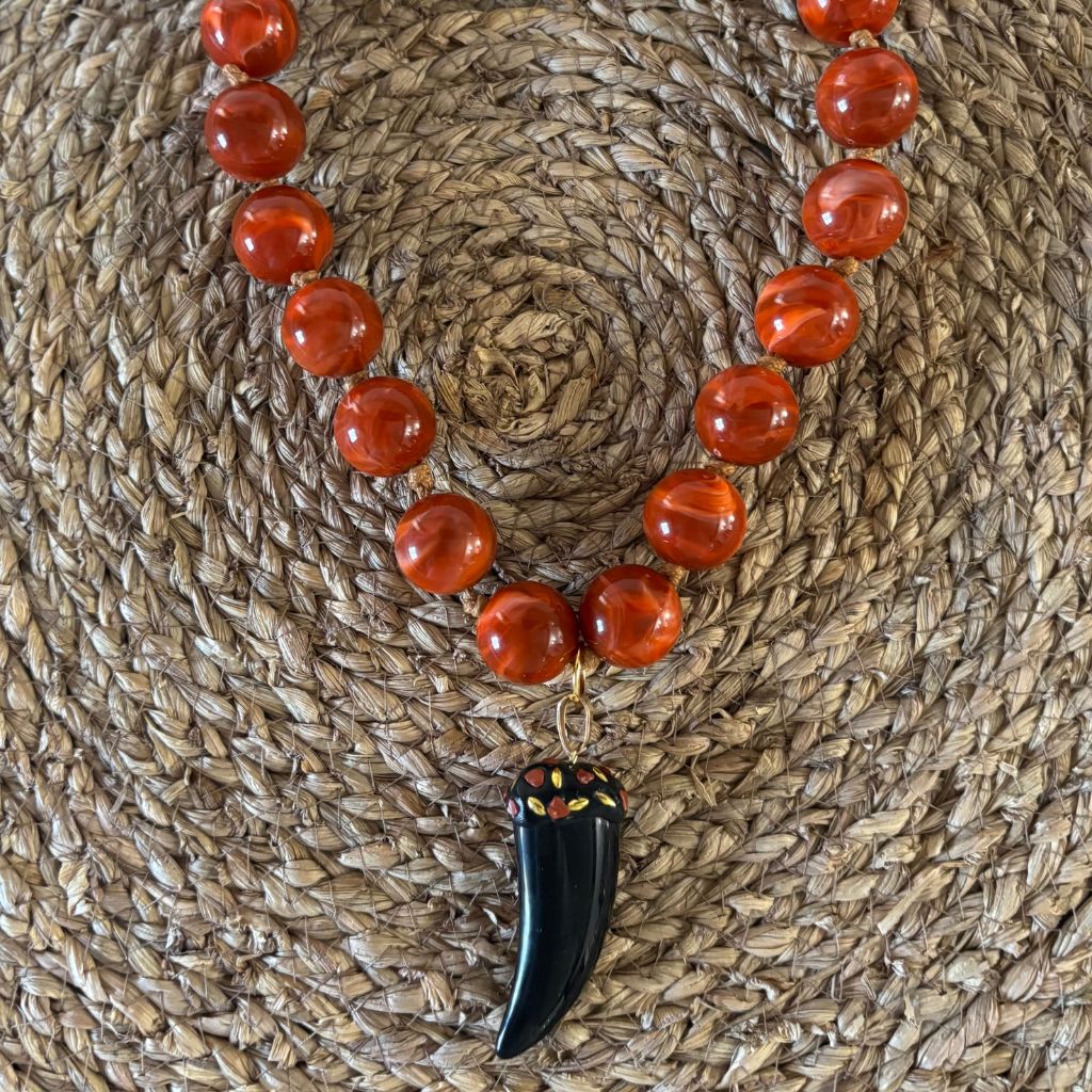 Collar de bolas marmoleadas en tono coral.