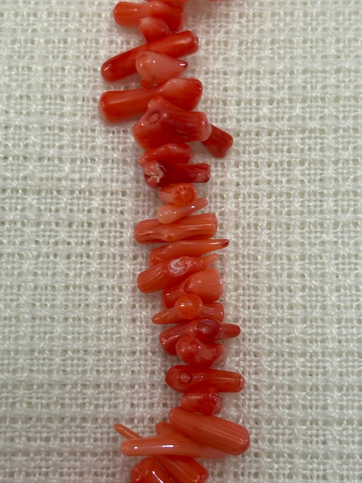 “Gargantilla de coral rosa natural con cuentas irregulares sobre fondo blanco”