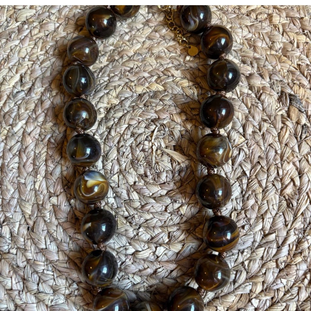 Collar de bolas marmoleado en tono marrón.